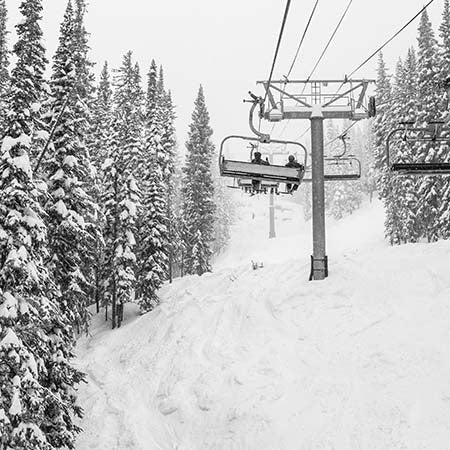 Ski lift in snowy Vail, Colorado surrounded by pine trees and fresh powder – minimalist black and white winter wall art for modern home or lodge décor.