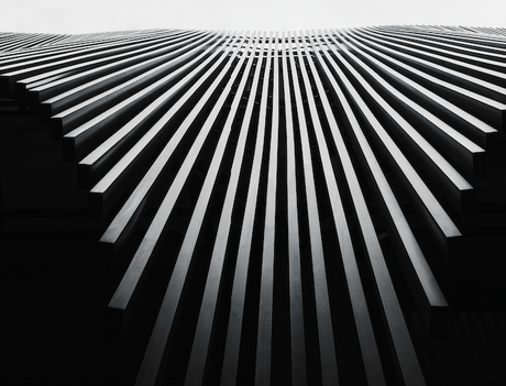 Black and white monochrome photograph featuring symmetrical architectural wall art in silver and grey tones.