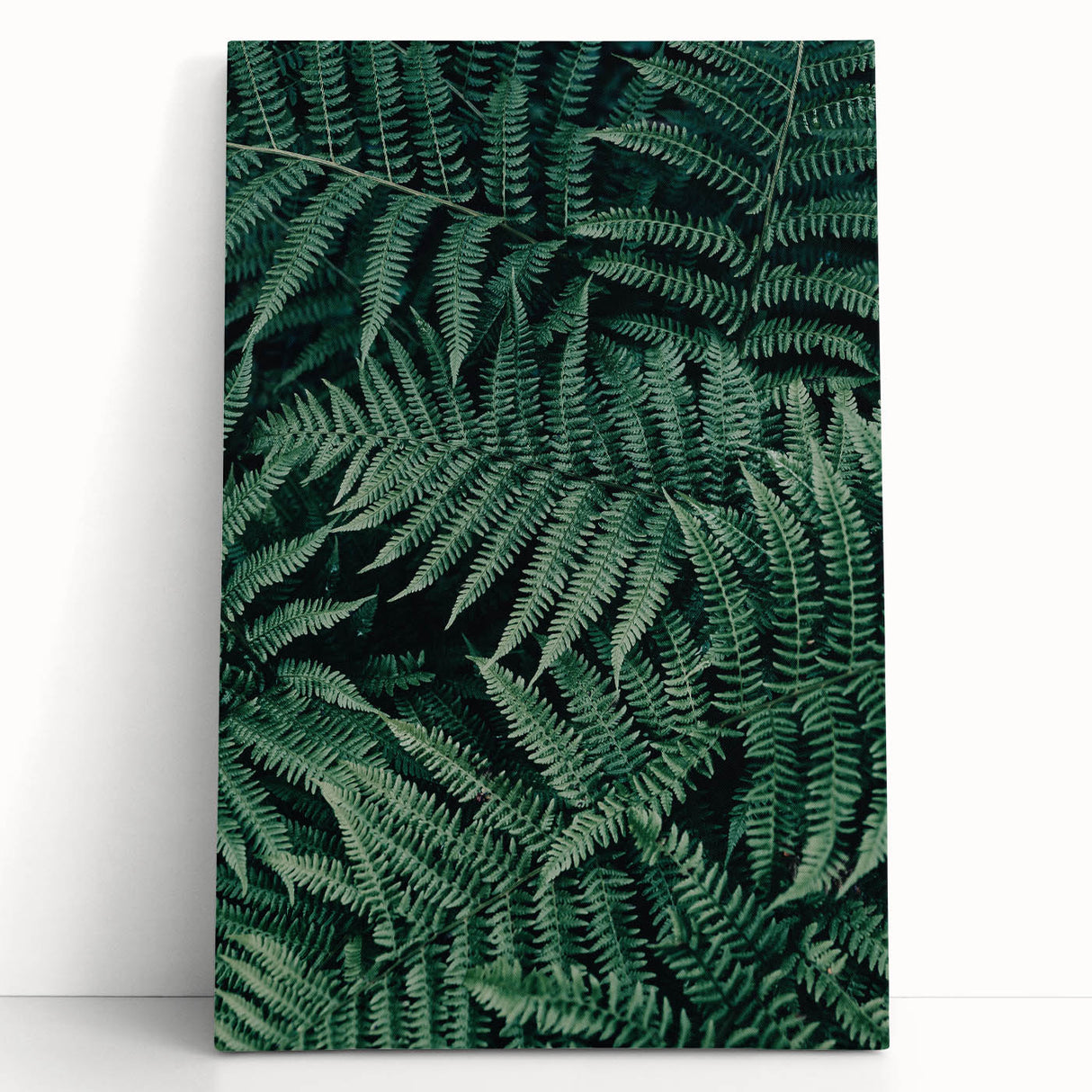Stretched canvas artwork featuring a vibrant abstract design with bold colors, leaning against a textured wall, ideal for modern home decor.