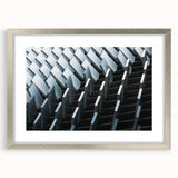 Abstract art print featuring swirling blue and silver tones on a framed canvas, suitable for bedroom or dining room decor.