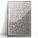 Framed abstract wall art featuring vibrant splatters in shades of blue, orange, and yellow, set in a sleek silver frame, perfect for modern decor.