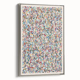 Framed abstract wall art featuring colorful splatter designs on a canvas, showcased from a side view with a sleek silver frame.