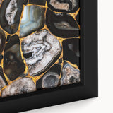 Close-up of a framed canvas wall art featuring an abstract design with vibrant strokes and lines in blue, orange, and yellow hues, perfect for modern decor.