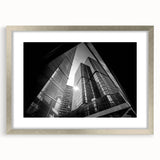 Abstract art print featuring geometric shapes in muted gray and blue tones on a framed silver mat.