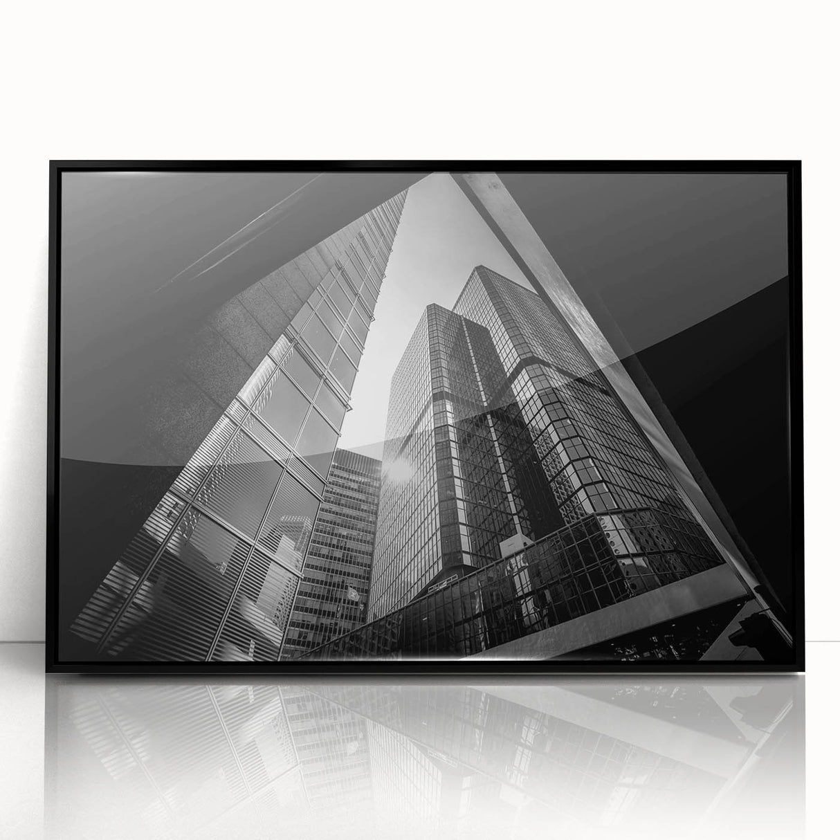 Large abstract wall art featuring geometric shapes in muted gray and blue tones on a black framed acrylic print.
