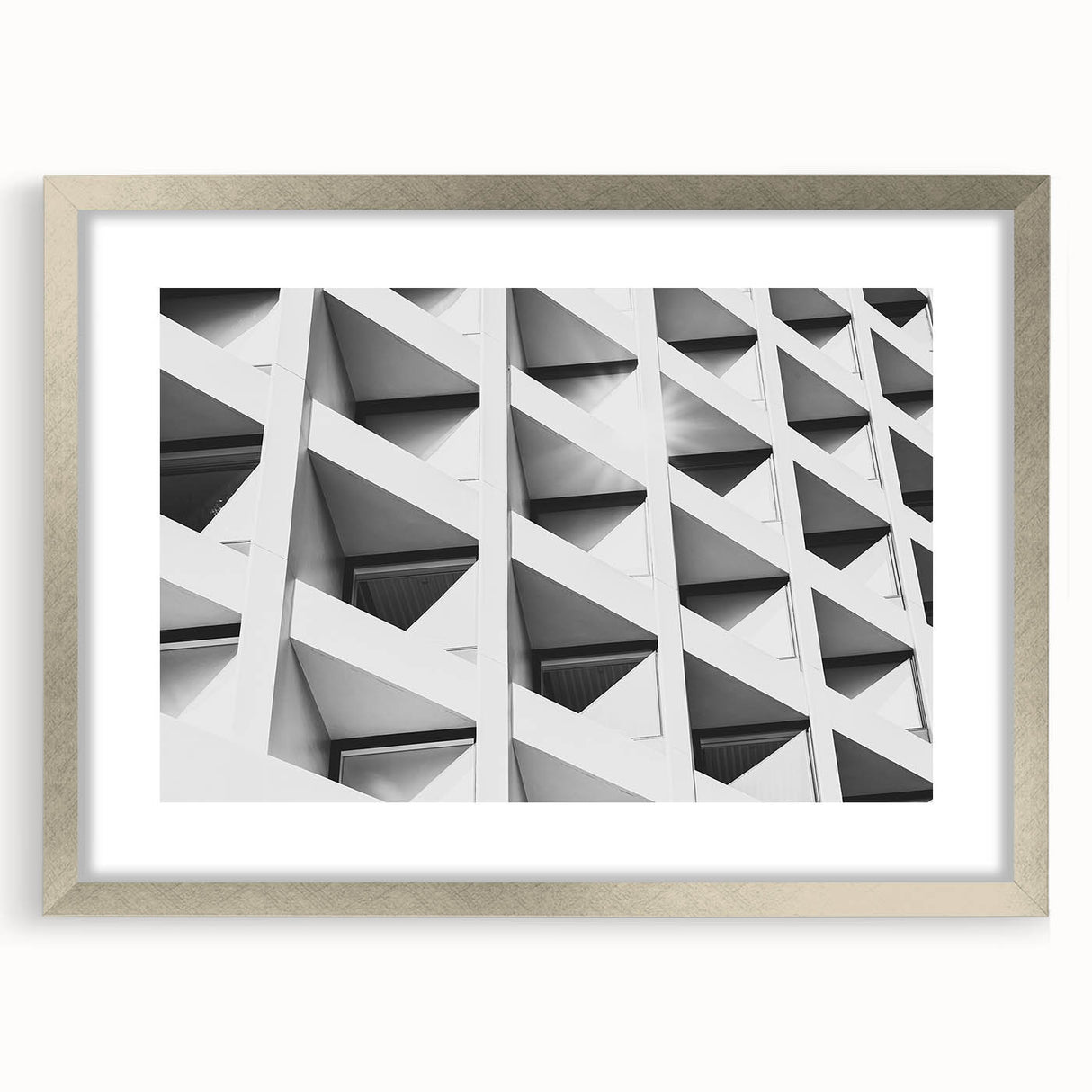 Abstract art print featuring geometric shapes in muted gray and silver tones on a framed canvas.