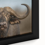 Close-up of a framed canvas wall art featuring a detailed illustration of a buffalo, showcasing its textured fur and majestic horns against a natural backdrop, perfect for wildlife enthusiasts.