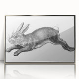 Framed wall art featuring a minimalist rabbit design in silver accents, set against a white background, ideal for modern home decor or animal-themed interiors.