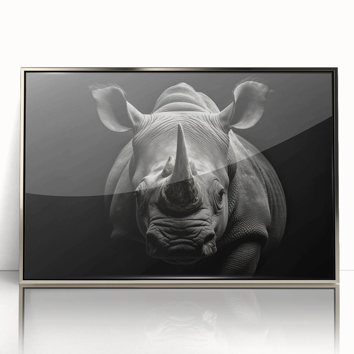Framed wall art featuring a striking front view of a rhinoceros, showcasing intricate details and a sleek silver-acrylic finish, perfect for wildlife enthusiasts.