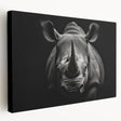 Stretched canvas wall art showcasing a side view of a majestic rhinoceros in a natural habitat, featuring earthy tones and intricate textures, perfect for wildlife enthusiasts.