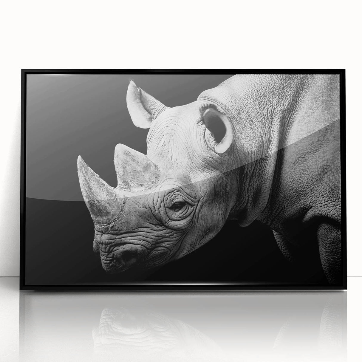 Framed wall art featuring a striking black and white rhinoceros design, showcasing intricate details and modern aesthetics, perfect for wildlife enthusiasts.