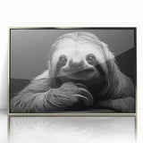 Framed wall art featuring a sloth design from the "Animals - A Wild Life" collection, showcasing a silver-acrylic finish that enhances its vibrant colors. This decorative piece adds a touch of nature-inspired charm to any room.