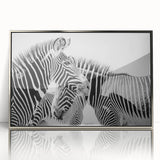 Framed wall art featuring a striking zebra design with vibrant black and white stripes, set in an elegant silver frame, perfect for enhancing any contemporary decor.