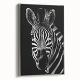 Framed wall art featuring a striking zebra design in black and white, elegantly displayed in a silver frame, perfect for wildlife-themed decor.