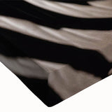 Close-up view of a vibrant stretched canvas wall art featuring a striking zebra design, showcasing intricate details and bold black and white stripes, perfect for animal lovers and modern decor.