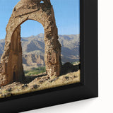 Close-up of a black wall art depicting ancient ruins in a textured style with colorful accents, framed canvas.