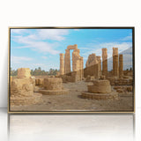 A large art print of ancient ruins in muted gold and beige tones, framed in acrylic.