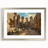 Textured print of abstract ancient ruins in muted earth tones, framed in silver, ideal for bedroom art.