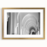 Abstract art print featuring a series of arches in muted gold and white tones on a framed canvas.