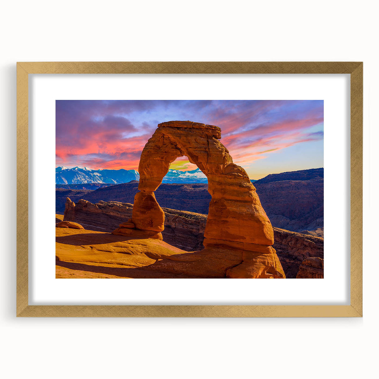 Abstract art print featuring symmetrical arch designs in gold and white tones, framed with a gold mat.