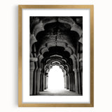 Abstract art print featuring symmetrical arch designs in muted gold and white, framed with a gold mat.