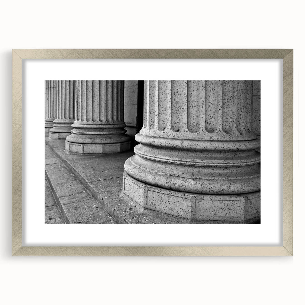 Textured art print featuring abstract columns in muted gray tones on a framed silver mat, suitable for bedroom decor.