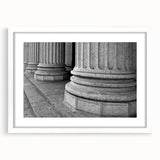 Abstract art print featuring geometric columns in gray tones, framed in white, suitable for bedroom or dining room decor.