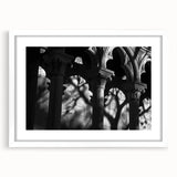 Abstract art print featuring a series of white columns in grayscale, presented in a white mat frame.