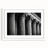 Abstract art print of white columns against a dark background, framed in white, suitable for dining room or bedroom decor.