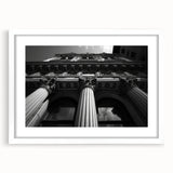 Abstract art print of architectural columns in muted gray, framed in white, ideal for dining room or bedroom decor.