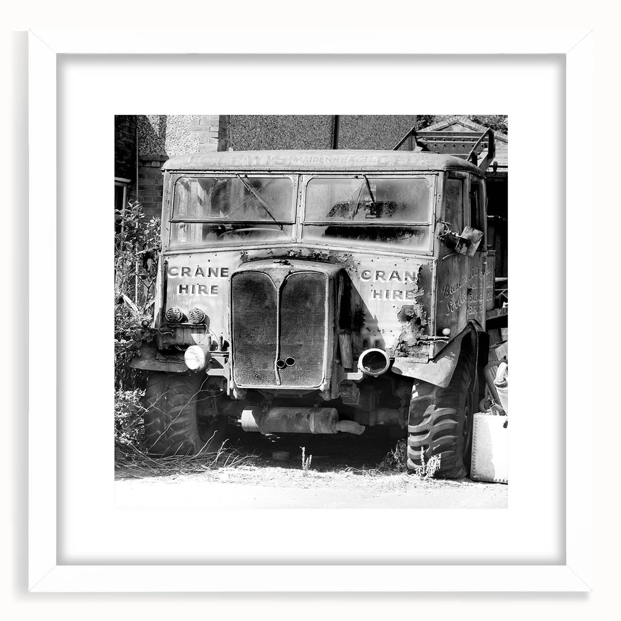 Abstract art print featuring derelict architectural design in muted gray and white tones, framed with a white mat.