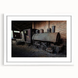 Abstract art print of a derelict building in muted grays and blues on a white framed canvas.