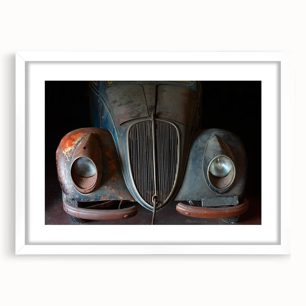Abstract art print featuring a derelict building in muted gray tones, framed in white, suitable for dining room decor.