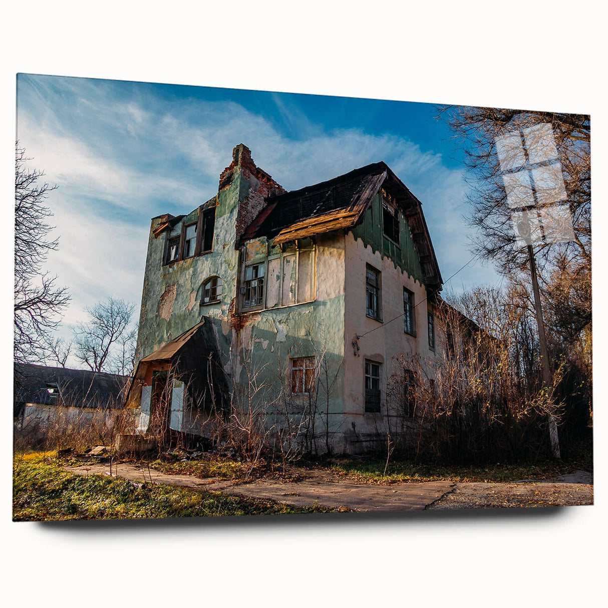 Large abstract wall art on acrylic glass depicting a derelict building, in muted earth tones.