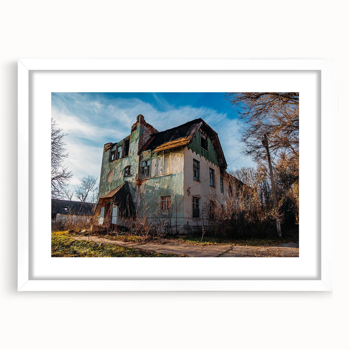 Abstract art print of a derelict building, using muted grays and whites on a framed white mat.