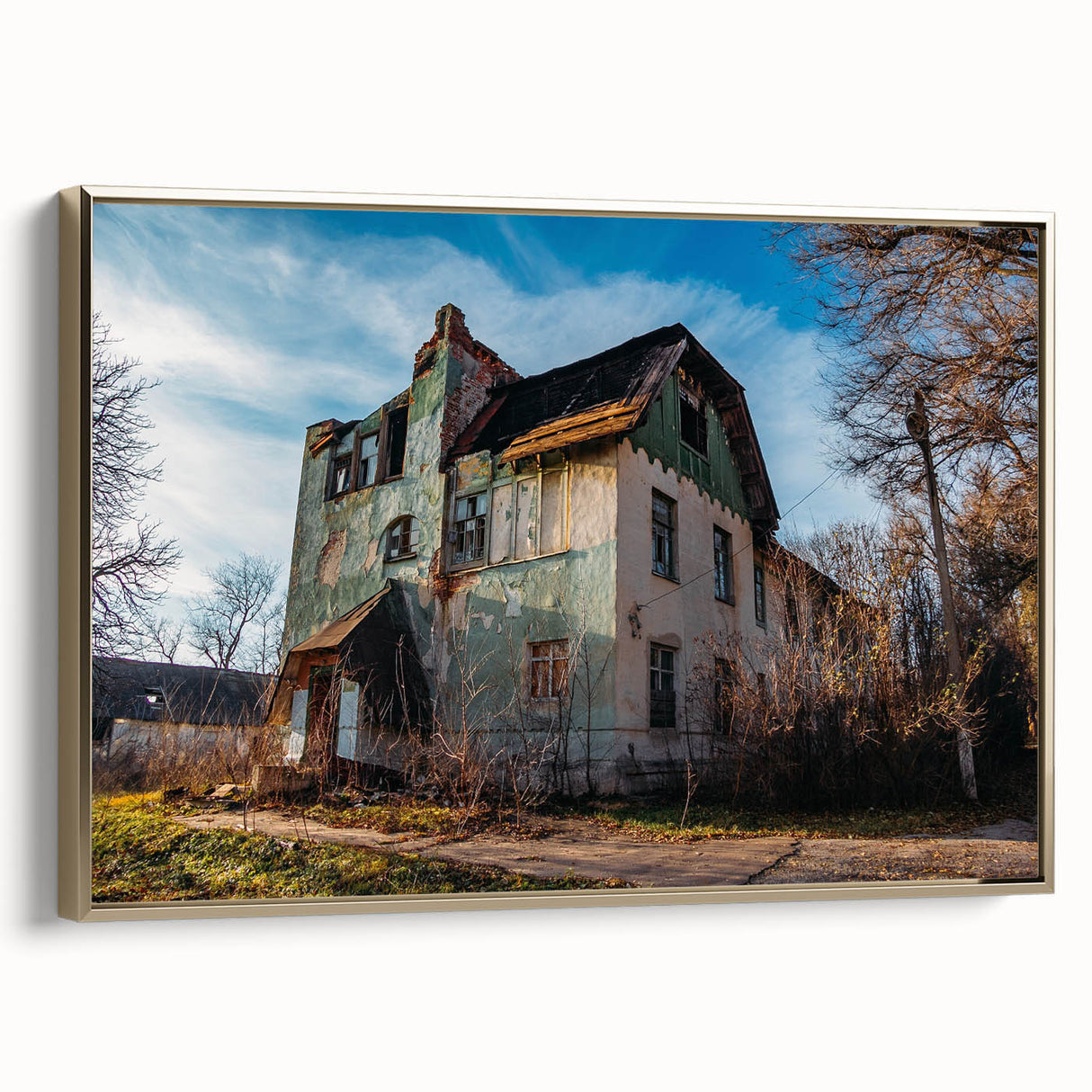Framed canvas featuring a landscape art painting of a derelict building in muted earth tones.