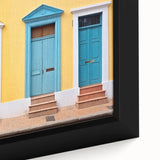 Close-up of a black framed canvas featuring a colorful, textured door design, ideal for extra large living room wall art.