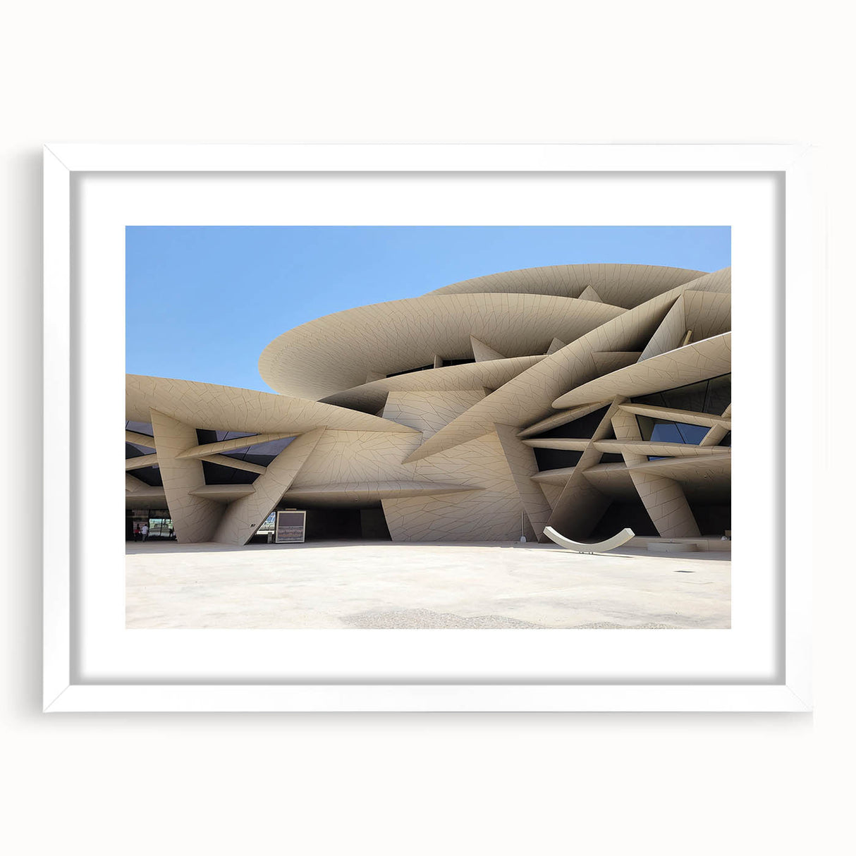 Abstract art print featuring geometric shapes in muted gray and blue tones on a framed white canvas.