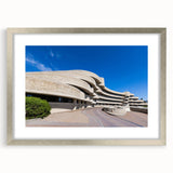 Textured abstract art print in muted grays and blues, framed in silver, ideal for modern bedroom ambiance.