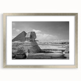Abstract art print of geometric pyramids in muted gray, framed in silver, ideal for modern dining room decor.