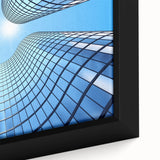 Close-up of a black wall art on framed canvas featuring a textured skyscraper design with colorful accents.