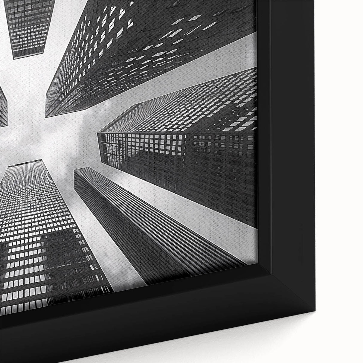 Close-up of a black framed canvas featuring a textured skyscraper design with colorful accents, ideal for living room decor.