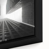 Close-up of a black wall art featuring a textured skyscraper design in vibrant colors on a framed canvas.