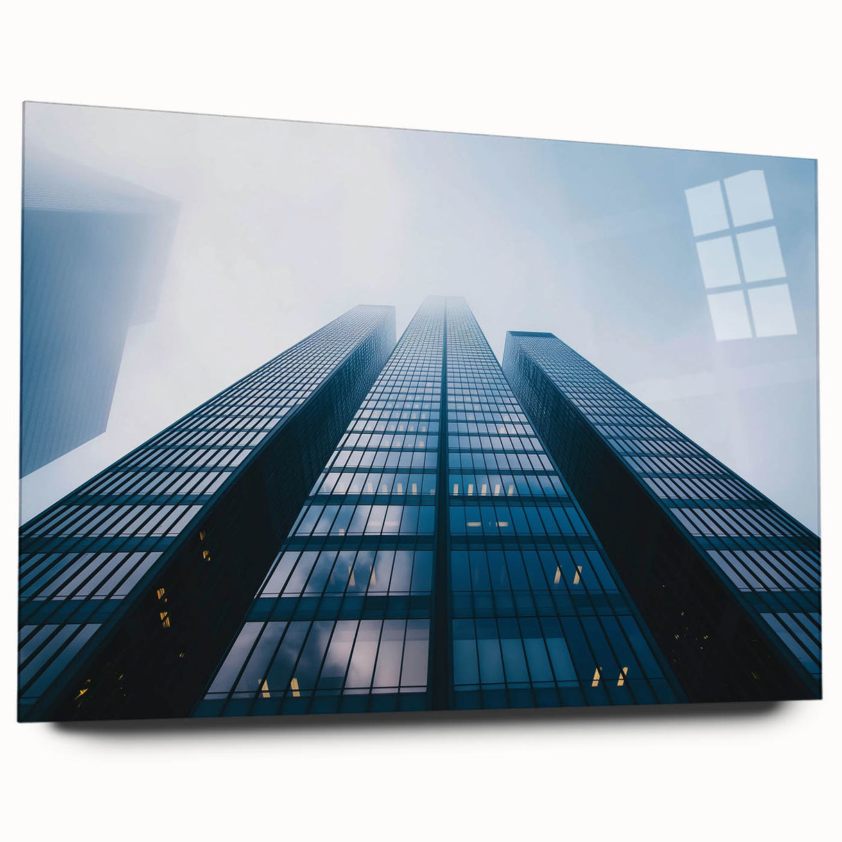Large abstract wall art of skyscrapers in muted gray and blue tones on acrylic glass.