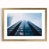 Textured abstract art print of a skyscraper, in muted metallic and gray tones, framed in gold.