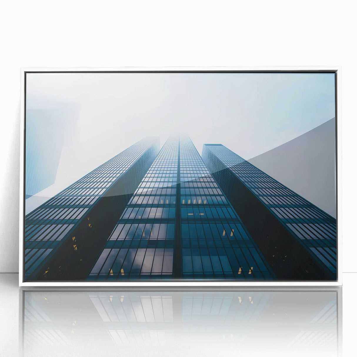 Large art print of a mid-century modernist skyscraper in muted gray tones on white framed acrylic.