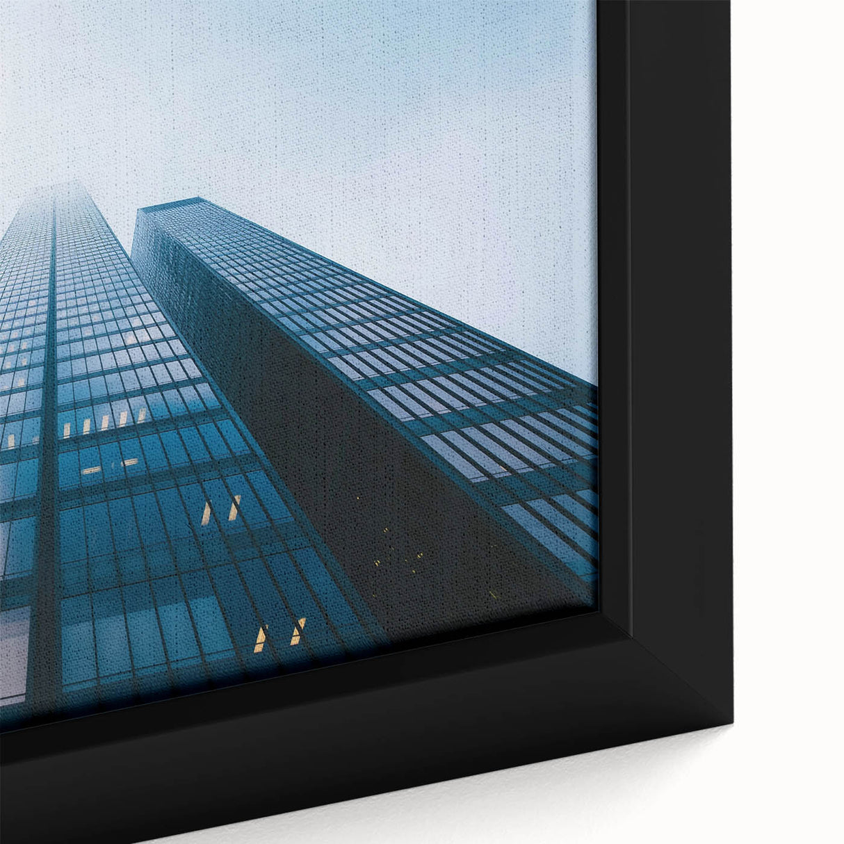 Close-up of a black framed canvas featuring a skyscraper design with colorful, textured details, ideal for living room decor.