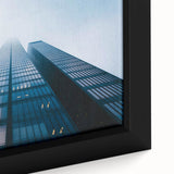 Close-up of a black framed canvas featuring a skyscraper design with colorful, textured details, ideal for living room decor.