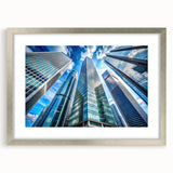 Abstract art print of geometric skyscrapers in silver frame, ideal for modern dining room decor.