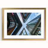 Textured art print of abstract skyscrapers in muted gray tones, framed in gold, ideal for modern bedroom ambiance.